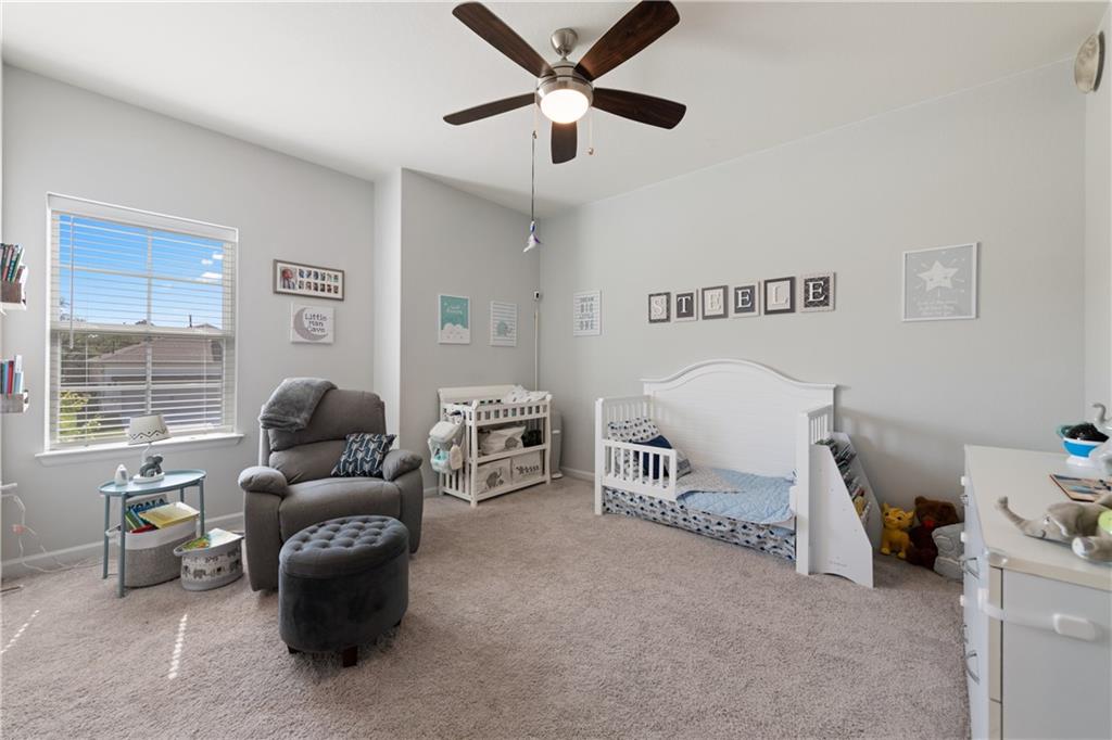 7117 Jument Drive Austin, TX 78738 - Photo 26 of 40 Carpeted bedroom with a crib and ceiling fan