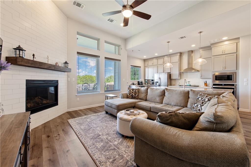 7117 Jument Drive Austin, TX 78738 - Photo 3 of 40 Living room with ceiling fan, wood finished floors, a fireplace, and recessed lighting