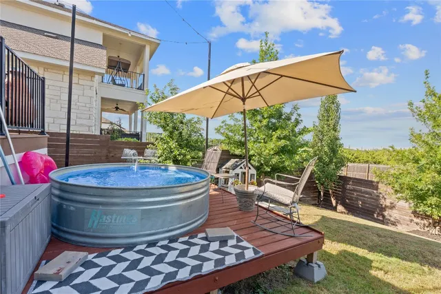 a view of a backyard with table and chairs under an umbrella