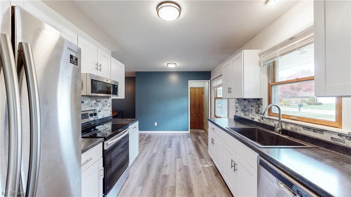 2936 Bancroft Road Akron, OH 44333 - Photo 5 of 35 Kitchen with backsplash and white cabinetry