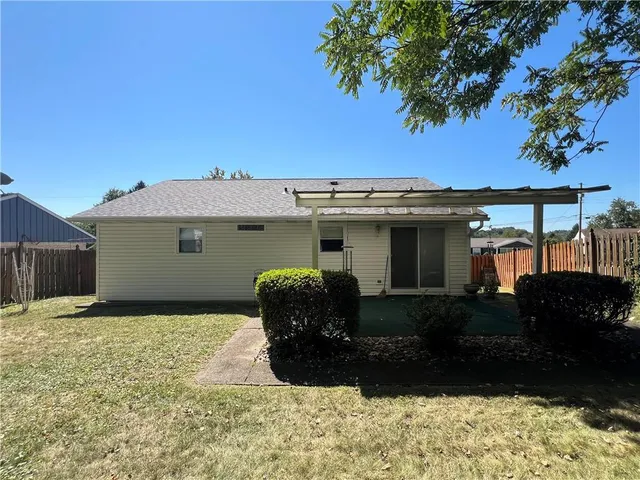 a front view of house with yard and trees in the background