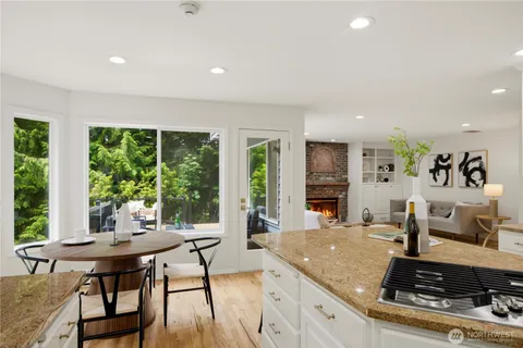 a kitchen with stainless steel appliances granite countertop a stove and a view of living room