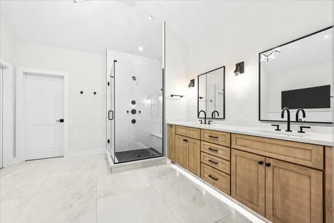 a bathroom with a double vanity sink mirror and shower