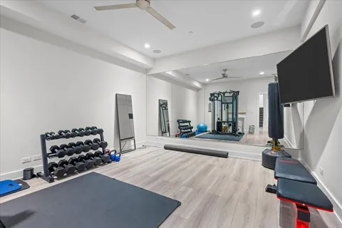a living room with furniture a flat screen tv and a refrigerator