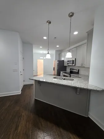 a open kitchen with stainless steel appliances granite countertop a sink a stove and a wooden floors