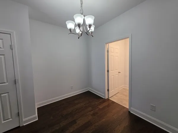a view of a chandelier in big room and wooden floor