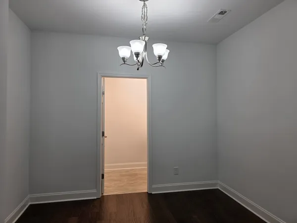 a room with wooden floor and chandelier