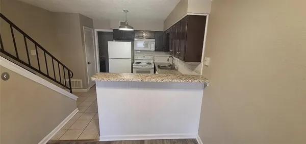 a kitchen with kitchen island a counter top space and cabinets