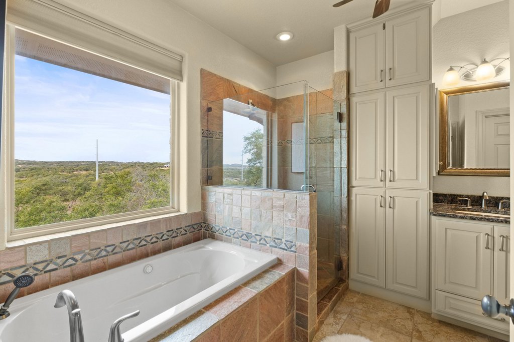 232 Crooked Oak Round Mountain, TX 78663 - Photo 18 of 40 Full bathroom with vanity, a shower stall, and a bath