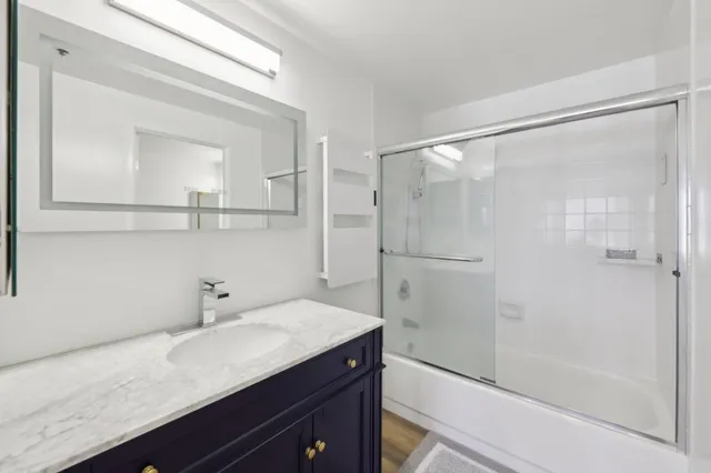 a bathroom with a granite countertop sink a toilet and shower