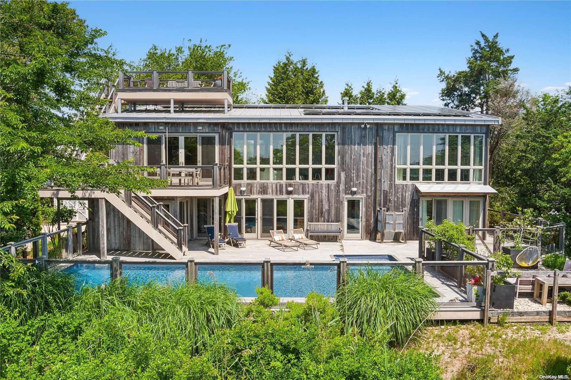 32 Tuthill Lane Remsenburg, NY 11960 - Photo 1 of 32 a front view of a house with a yard table and chairs