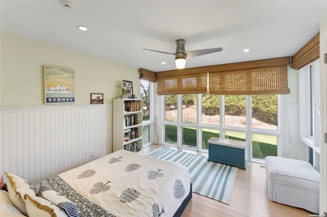 a bedroom with a bed and a large window with outer view