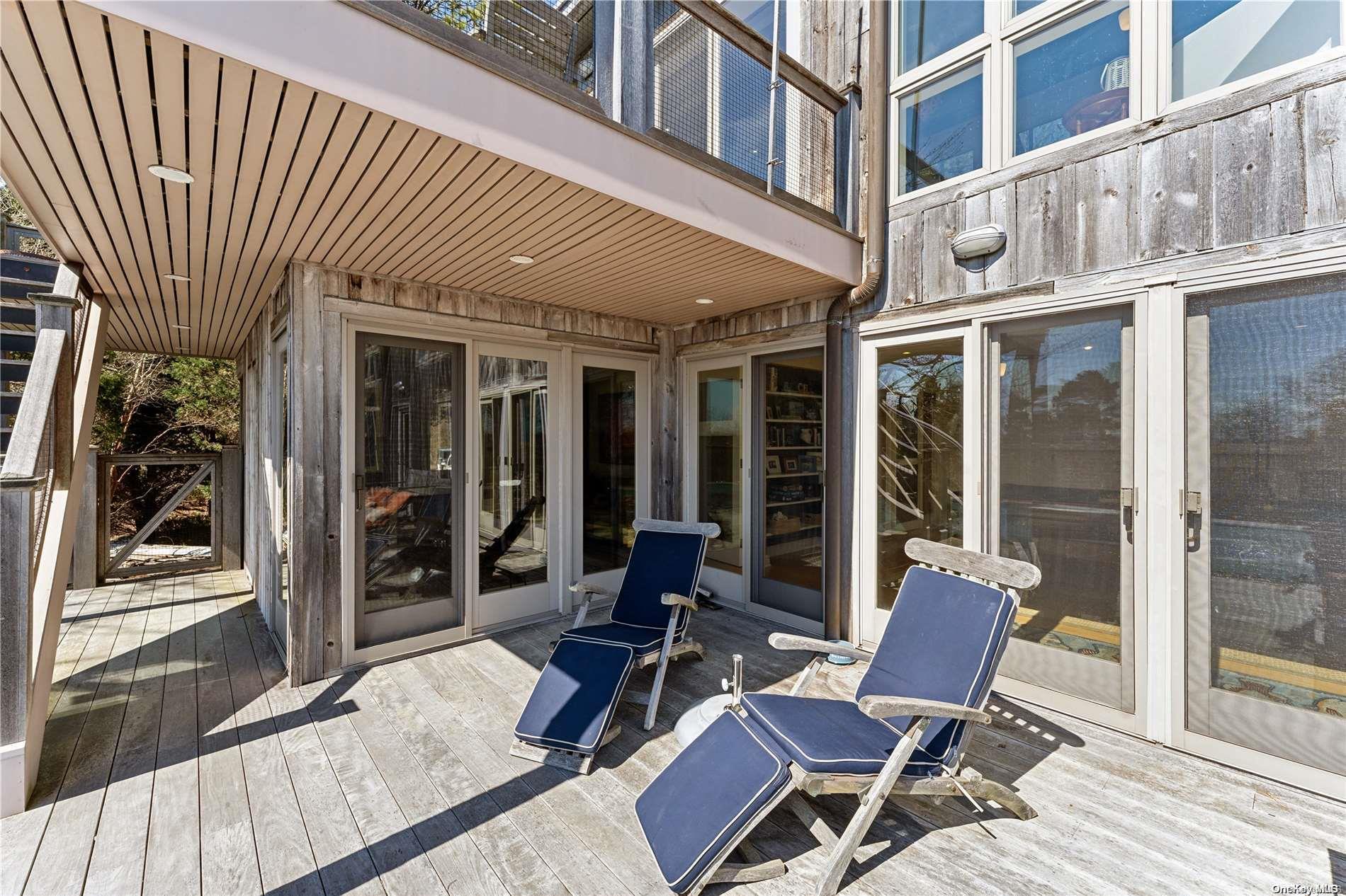 32 Tuthill Lane Remsenburg, NY 11960 - Photo 23 of 32 a view of a patio with table and chairs and floor to ceiling window wooden floor and floor to ceiling window