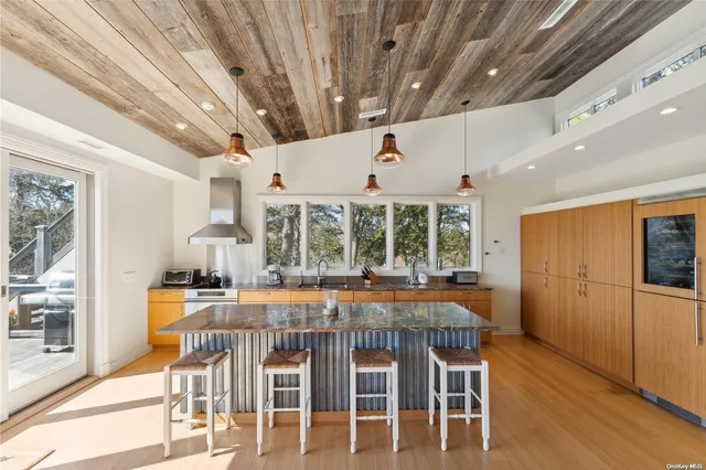 a dining room with furniture large windows and wooden floor