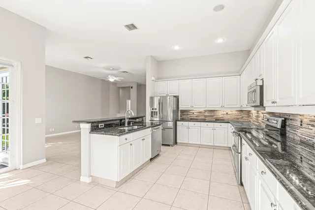 a kitchen with stainless steel appliances granite countertop a sink and a stove