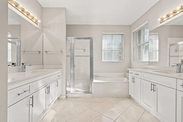 a spacious bathroom with a granite countertop sink a mirror a shower and a bathtub
