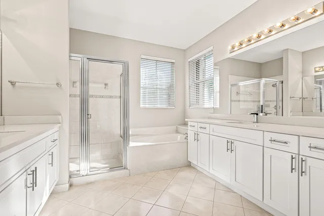 a spacious bathroom with 2 sink bathtub and a mirror