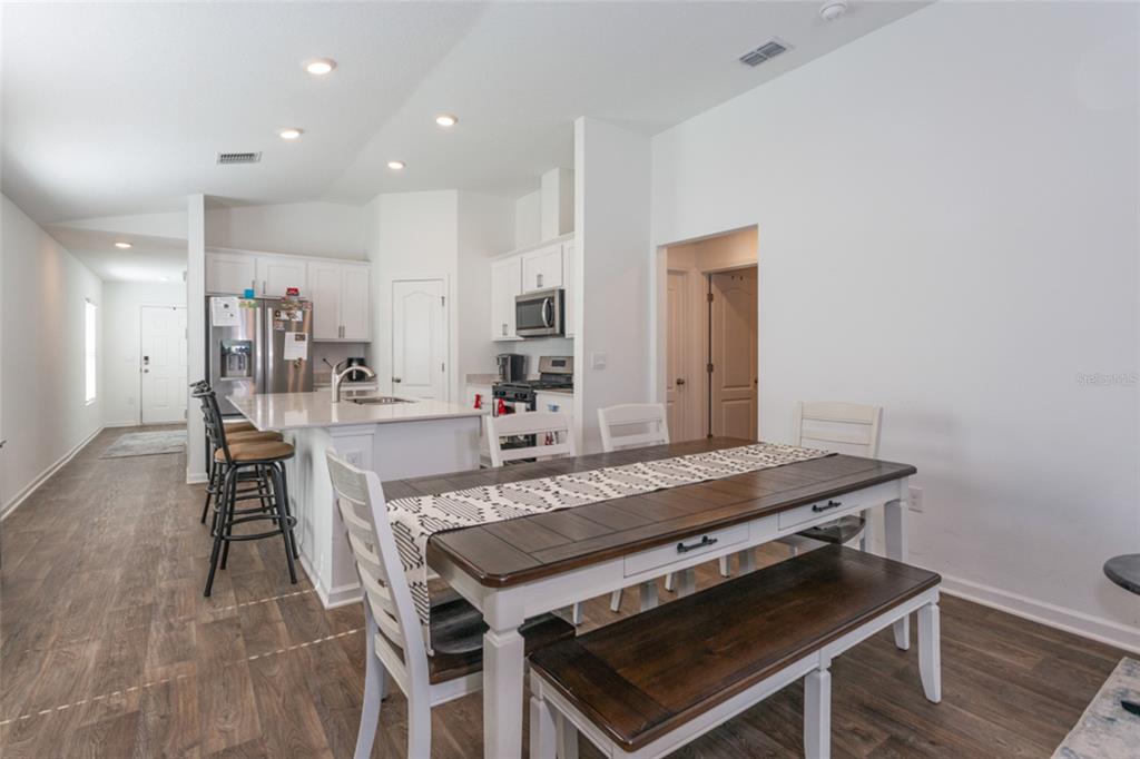 18 Bogey Place Bunnell, FL 32110 - Photo 11 of 40 a dining hall with stainless steel appliances granite countertop a stove a sink dishwasher and a refrigerator with wooden floor