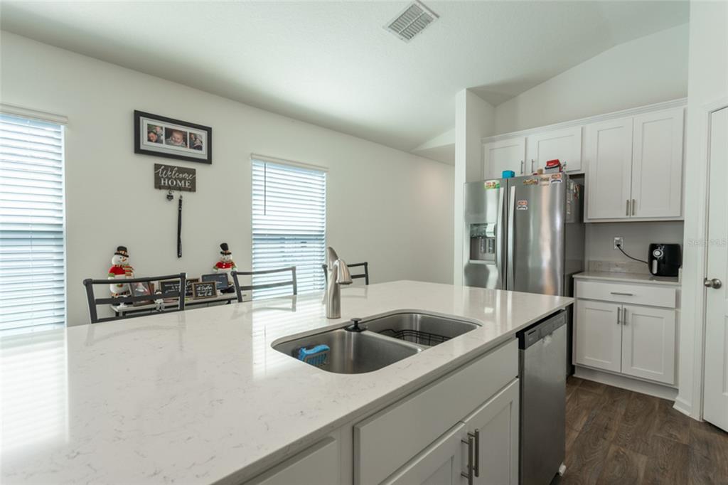 18 Bogey Place Bunnell, FL 32110 - Photo 7 of 40 a kitchen with a sink a refrigerator and cabinets