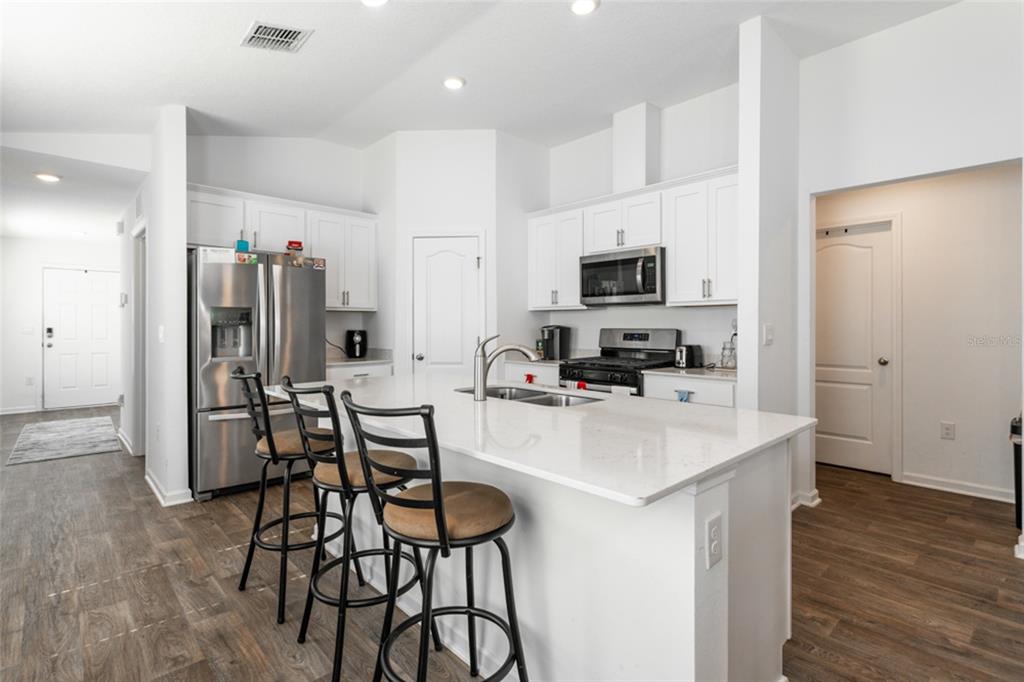18 Bogey Place Bunnell, FL 32110 - Photo 9 of 40 a kitchen with stainless steel appliances a refrigerator stove microwave and cabinets
