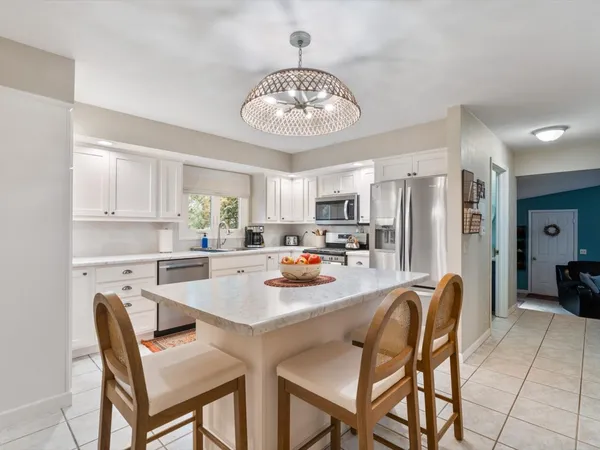 a view of a dining room with furniture and a chandelier