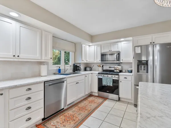 a kitchen with stainless steel appliances granite countertop a refrigerator sink and cabinets