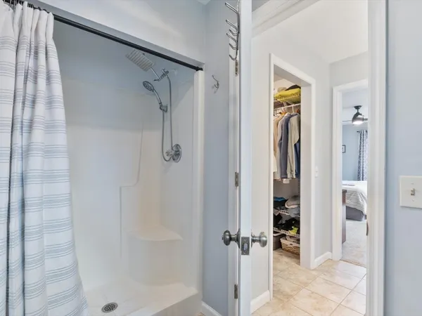 a bedroom with a large bed and a ceiling fan