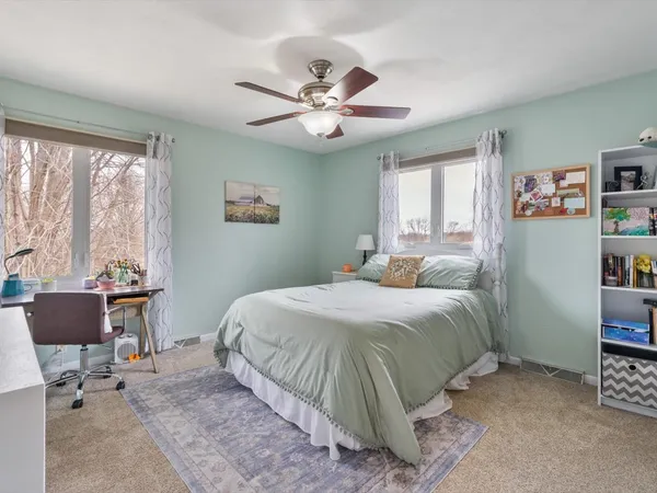 a bedroom with a bed a desk and a chandelier