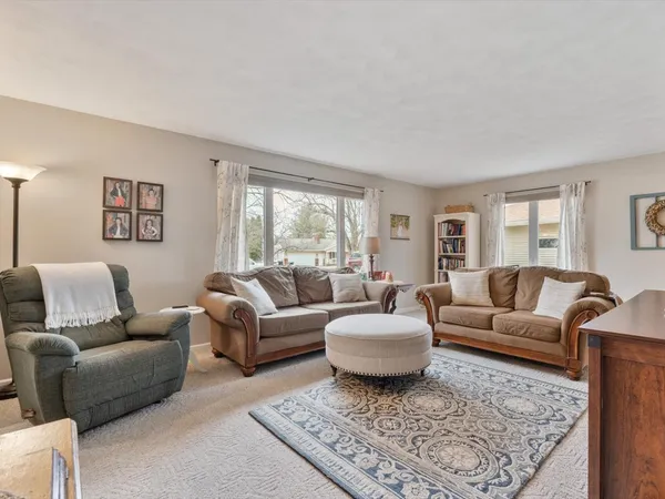a living room with furniture a rug a lamp and a table