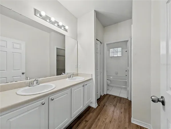 a spacious bathroom with a double vanity sink a mirror and shower