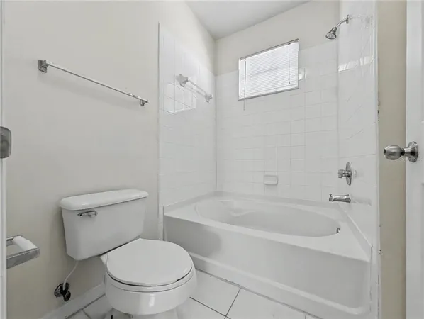 a white toilet sitting next to a bath tub and a shower