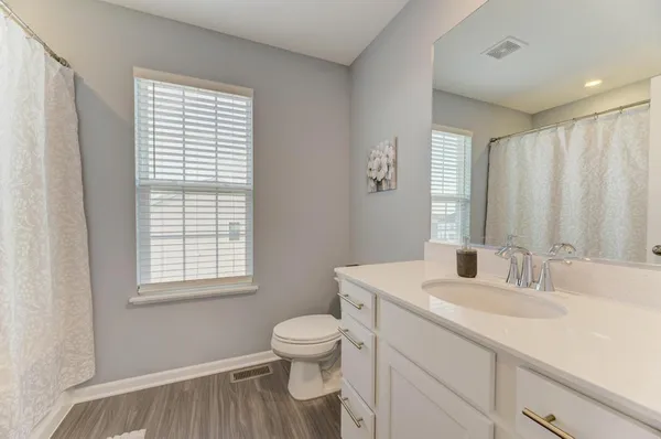 a bathroom with a sink a toilet and a window