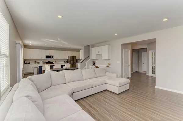 a living room with furniture and view of kitchen
