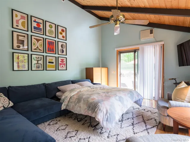 a bedroom with a bed couch and book shelf
