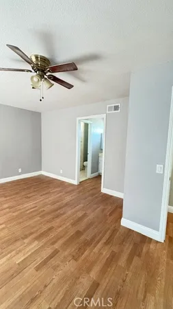 a view of a room with wooden floor and a ceiling fan
