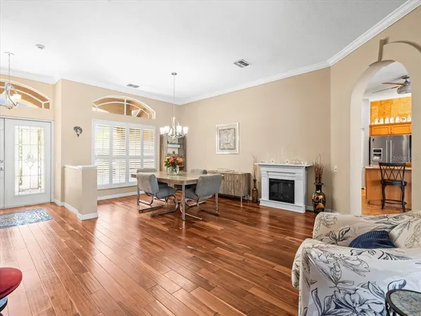 a kitchen with stainless steel appliances granite countertop a table chairs and a refrigerator