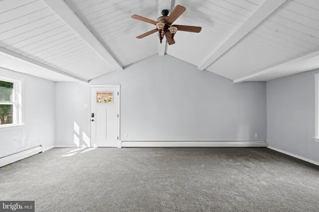 a view of a big room with wooden floor and windows