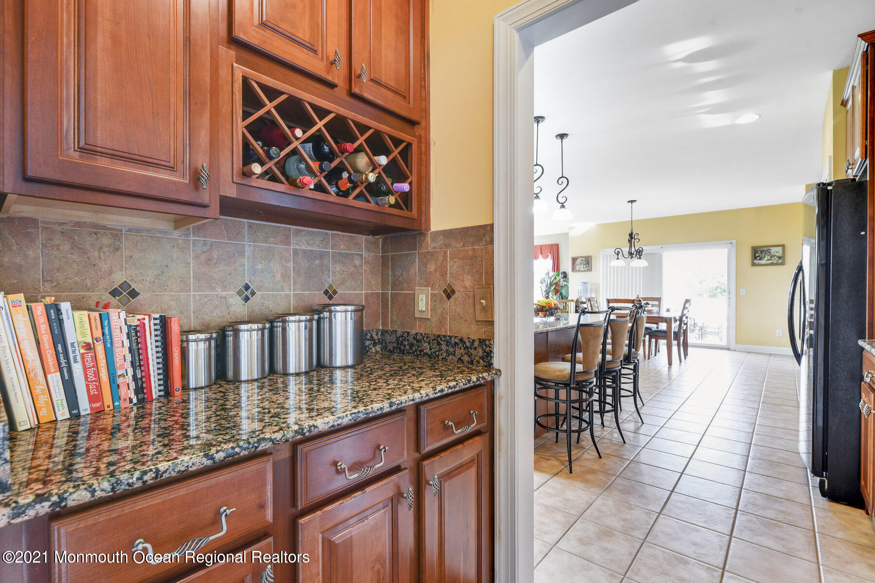 3 Great Bridge Road Freehold, NJ 07728 - Photo 16 of 40 a kitchen with stainless steel appliances granite countertop a table chairs and a view of living room