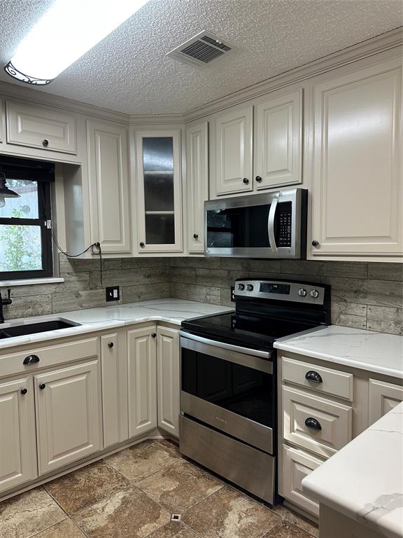 137 Oakview Circle Waco, TX 76705 - Photo 13 of 35 a kitchen with stainless steel appliances granite countertop a stove and a sink