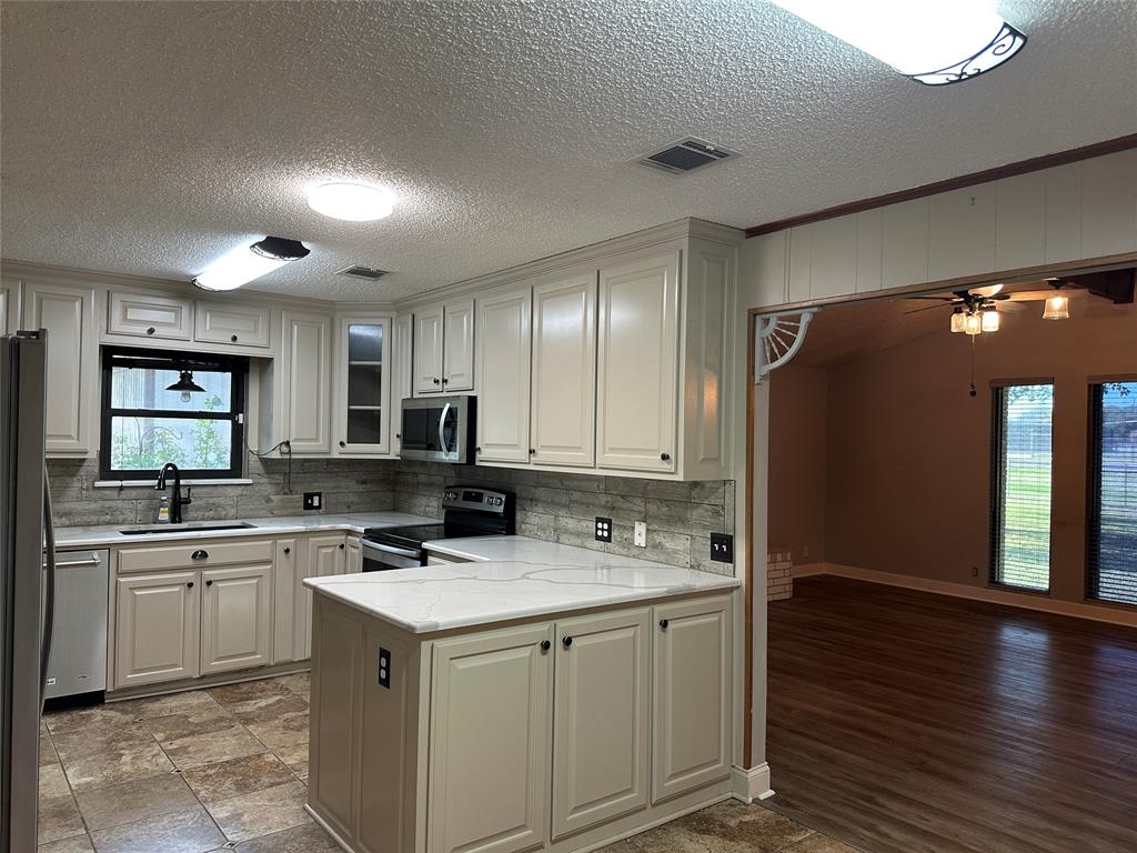 137 Oakview Circle Waco, TX 76705 - Photo 15 of 35 a kitchen with a sink cabinets and wooden floor