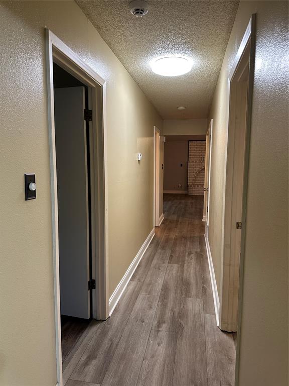 137 Oakview Circle Waco, TX 76705 - Photo 19 of 35 a view of a hallway with wooden floor and a bathroom