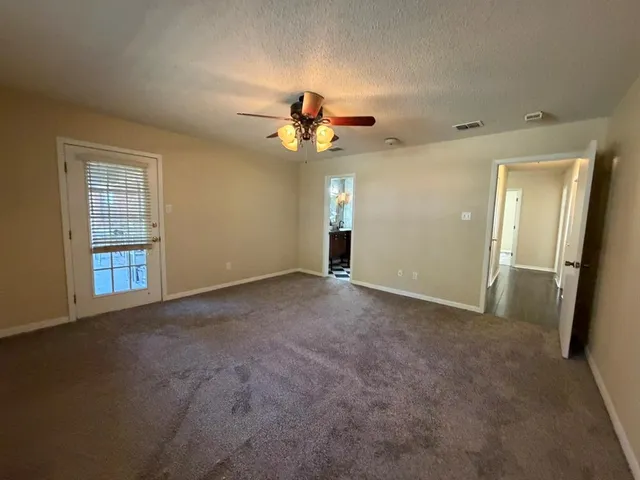 a view of a big room with chandelier fan and windows