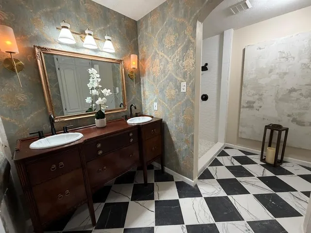 a room with a black white checkered floor with a mirror and a black shower