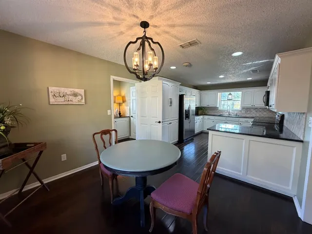a kitchen with a table chairs a stove a dining table and chairs