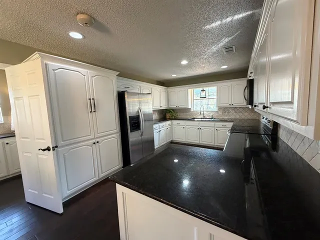 a kitchen with stainless steel appliances a refrigerator sink and cabinets