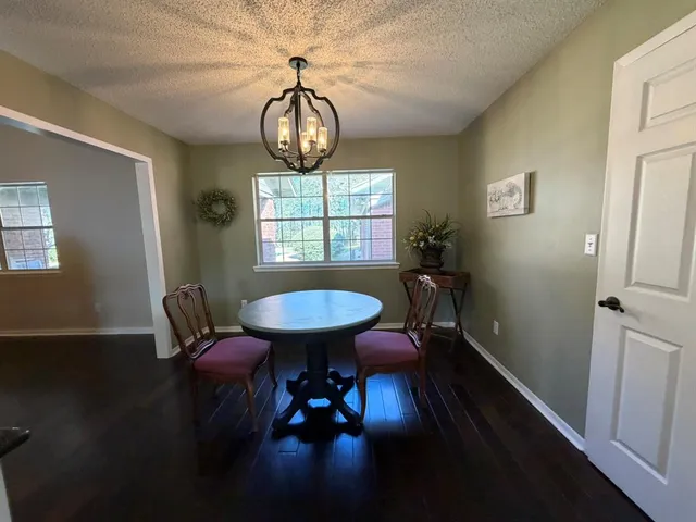 a view of a dining room with furniture wooden floor and chandelier