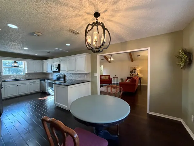 a very nice looking dining room with a table chairs and a chandelier