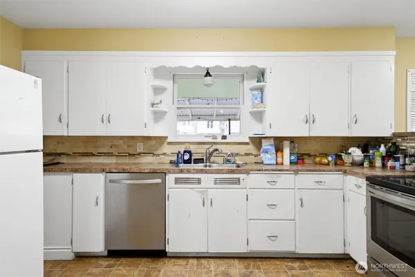 a kitchen with granite countertop white cabinets and white appliances
