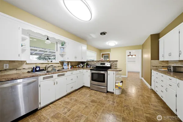 a kitchen with granite countertop white cabinets and white appliances