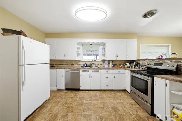a kitchen with a sink a refrigerator and cabinets